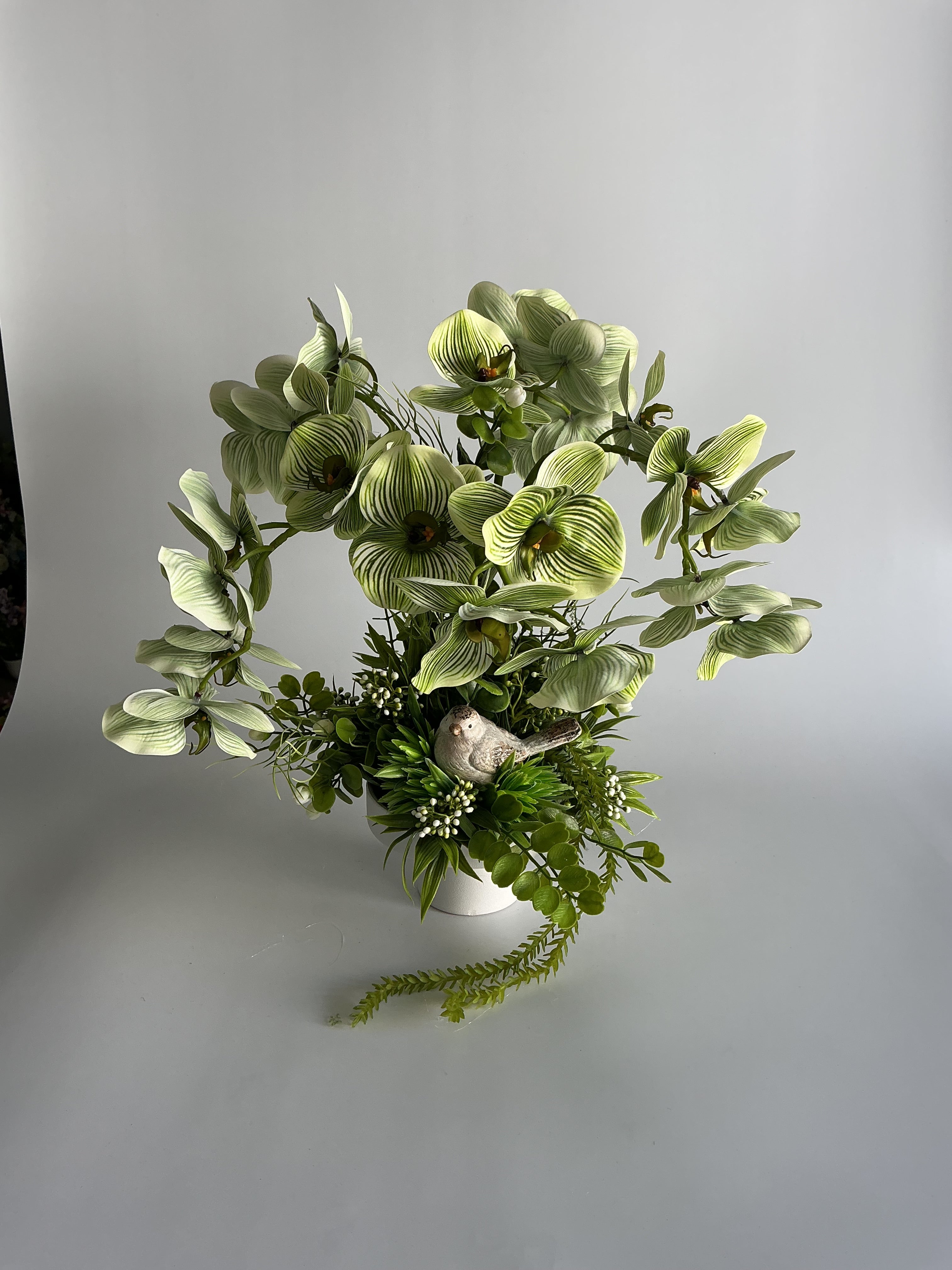 Stroik z orchideą i figurką ptaszka