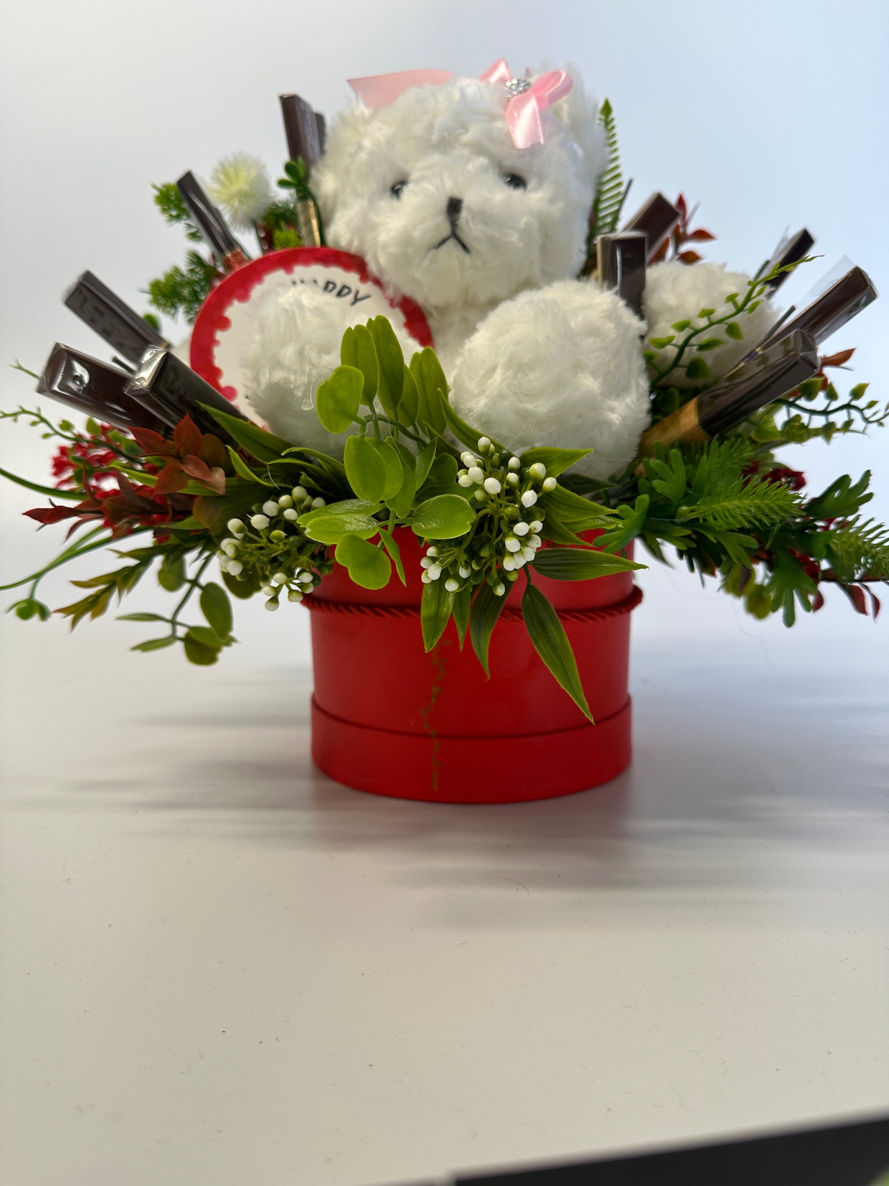Czerwony flowerbox z białym misiem i słodyczami